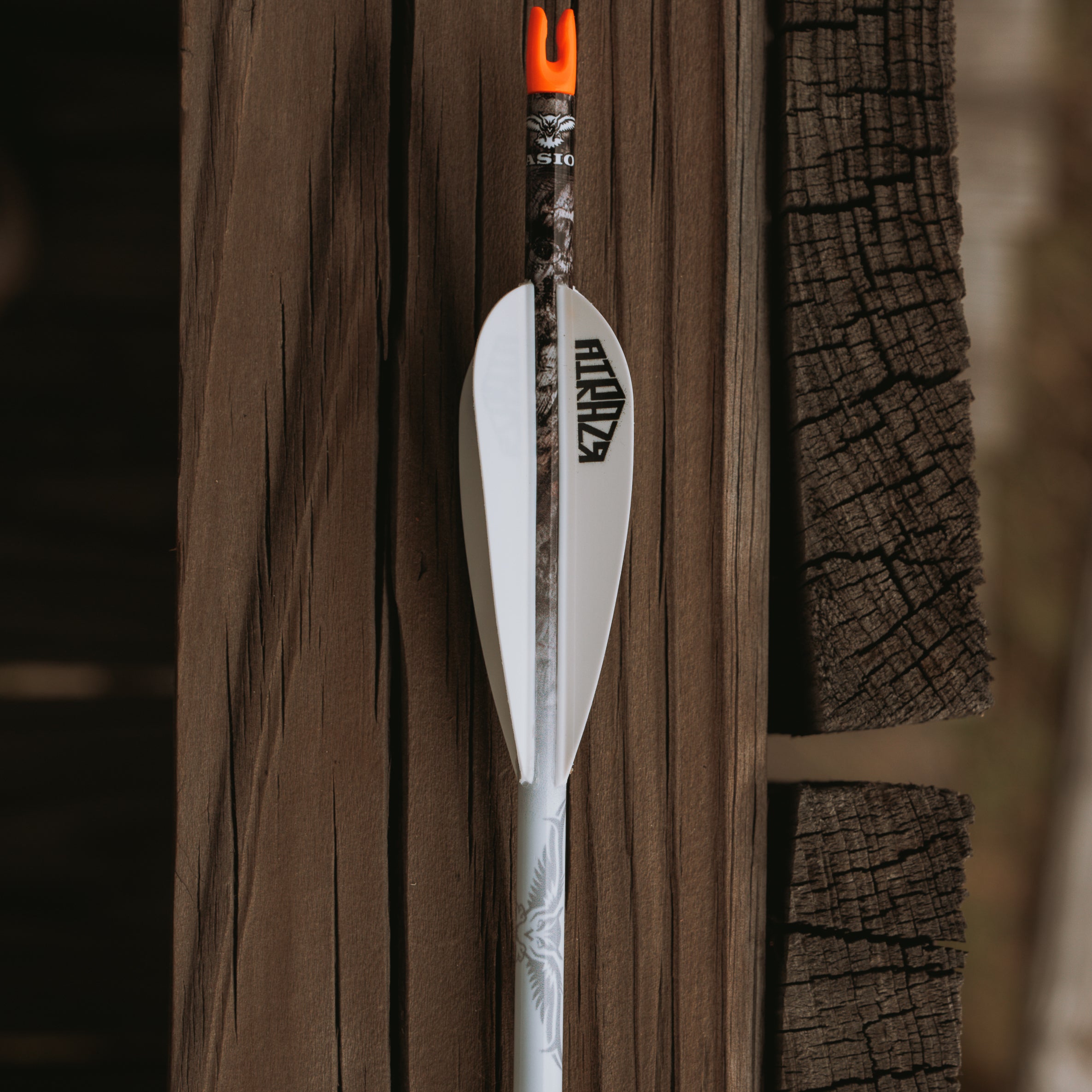 Archery Arrow Wrap with unique camo pattern displayed on one arrow with a wood background