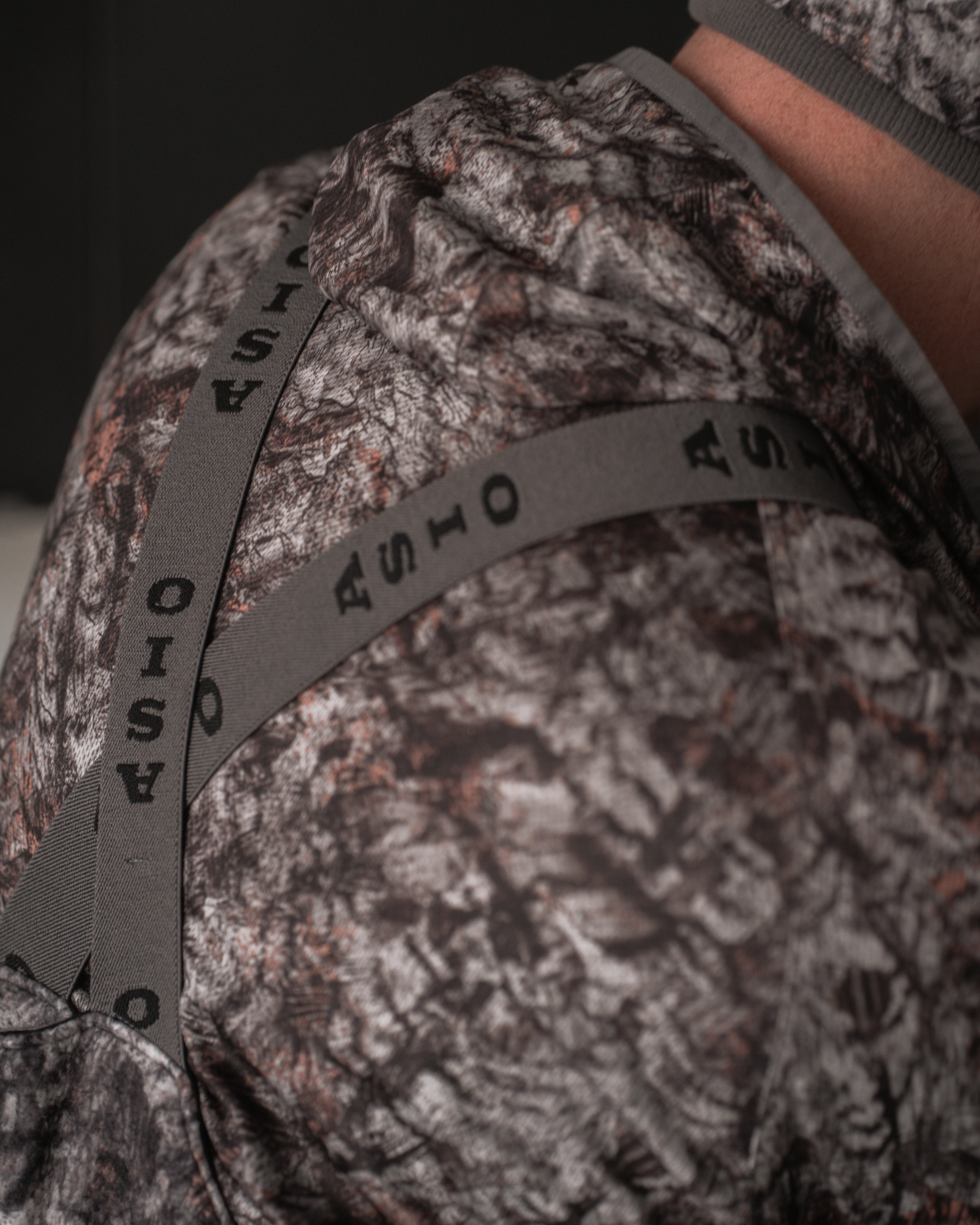 Rear view of ASIO branded suspenders crossed over the back of RAPTOR camo Heavyweight Bib