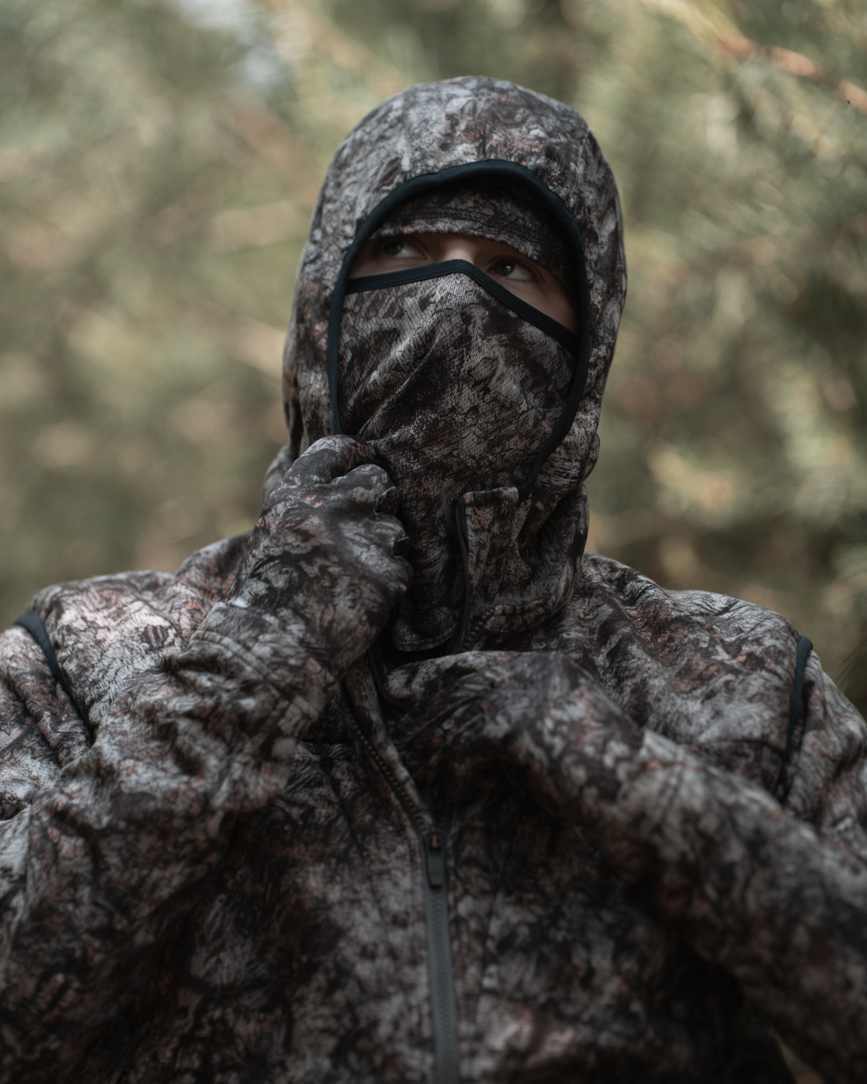 ASIO Midweight Hoodie in Raptor Camo with integrated face mask in use for concealment.
