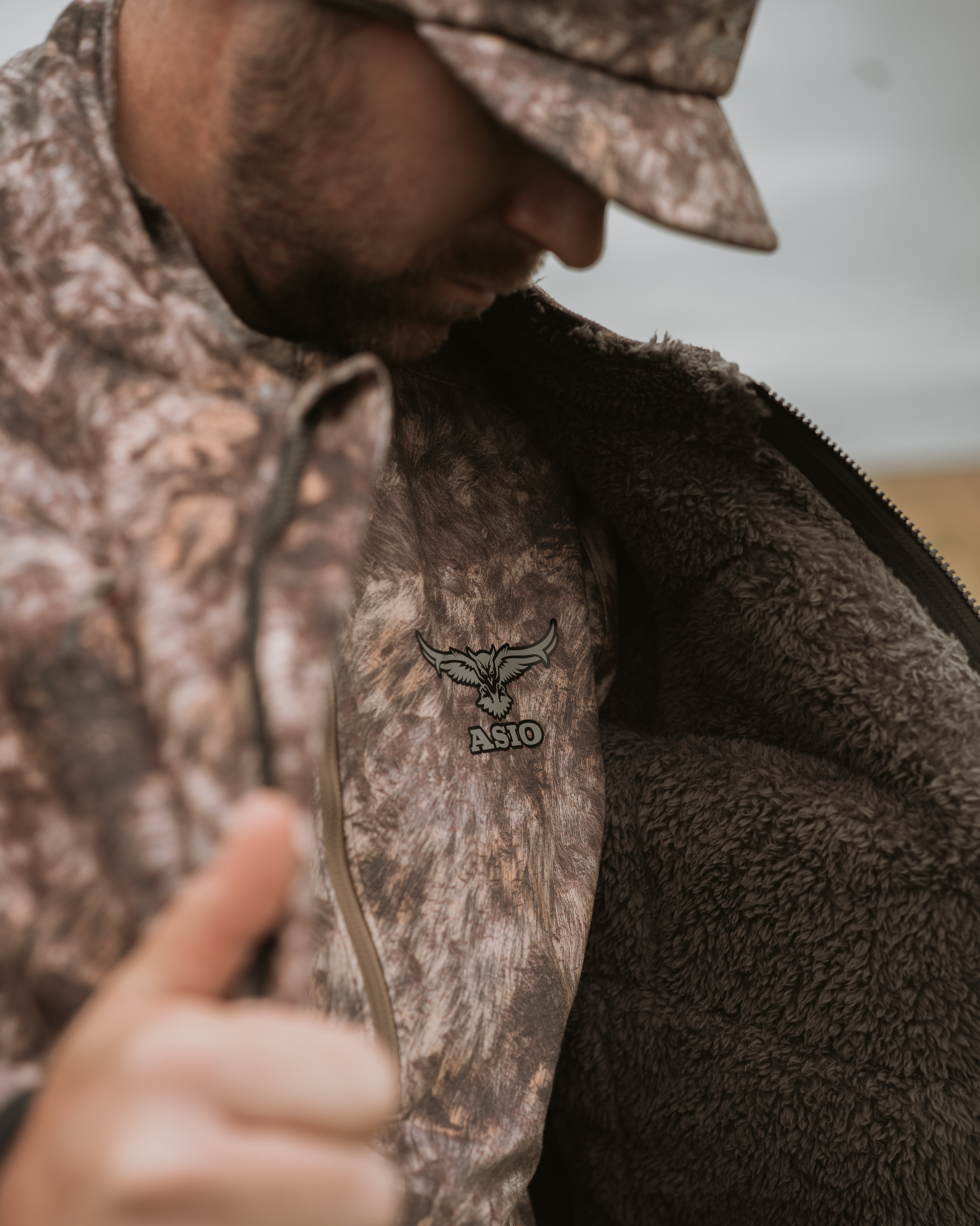 Close-up of ASIO Gear Midweight Sherpa Jacket in RAPX CAMO® highlighting ultra-soft sherpa fleece interior for warmth and stealth during whitetail bowhunts.