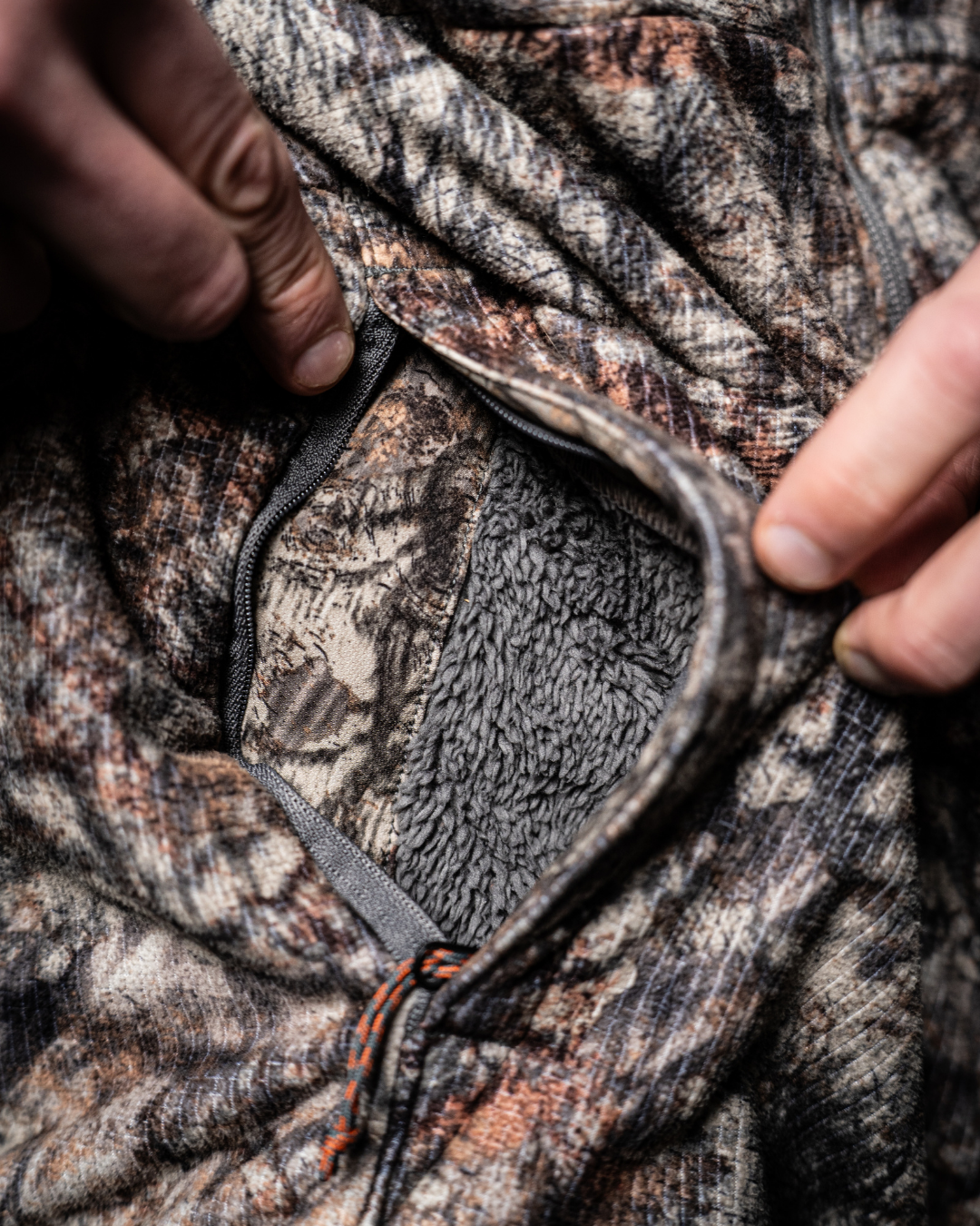 Close up of the ASIO Gear Midweight Sherpa Jacket hand pocket with soft sherpa fleece lining for added warmth during cold weather hunts.