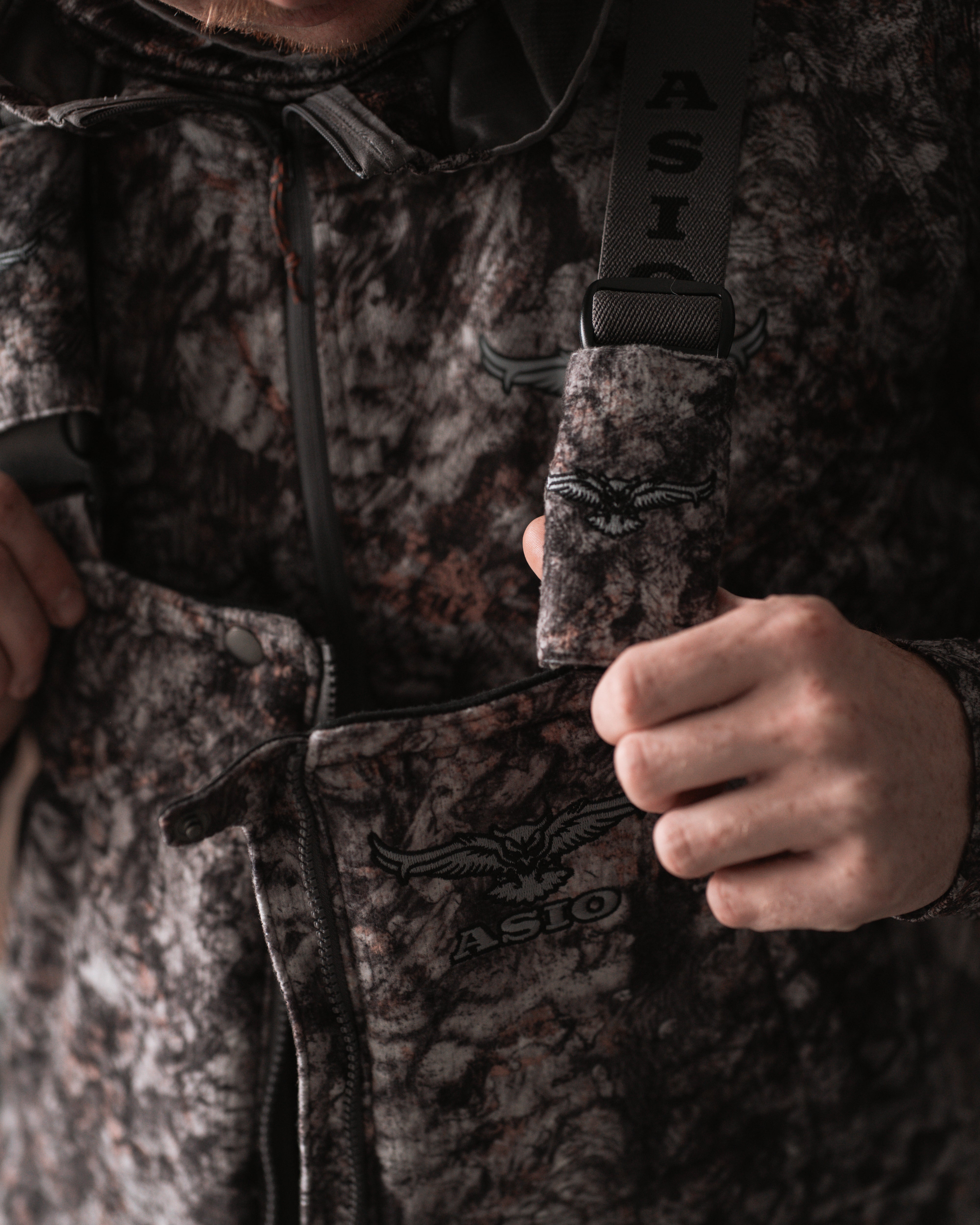 hunter showing elastic stretch on midweight sherpa bib in raptor camo