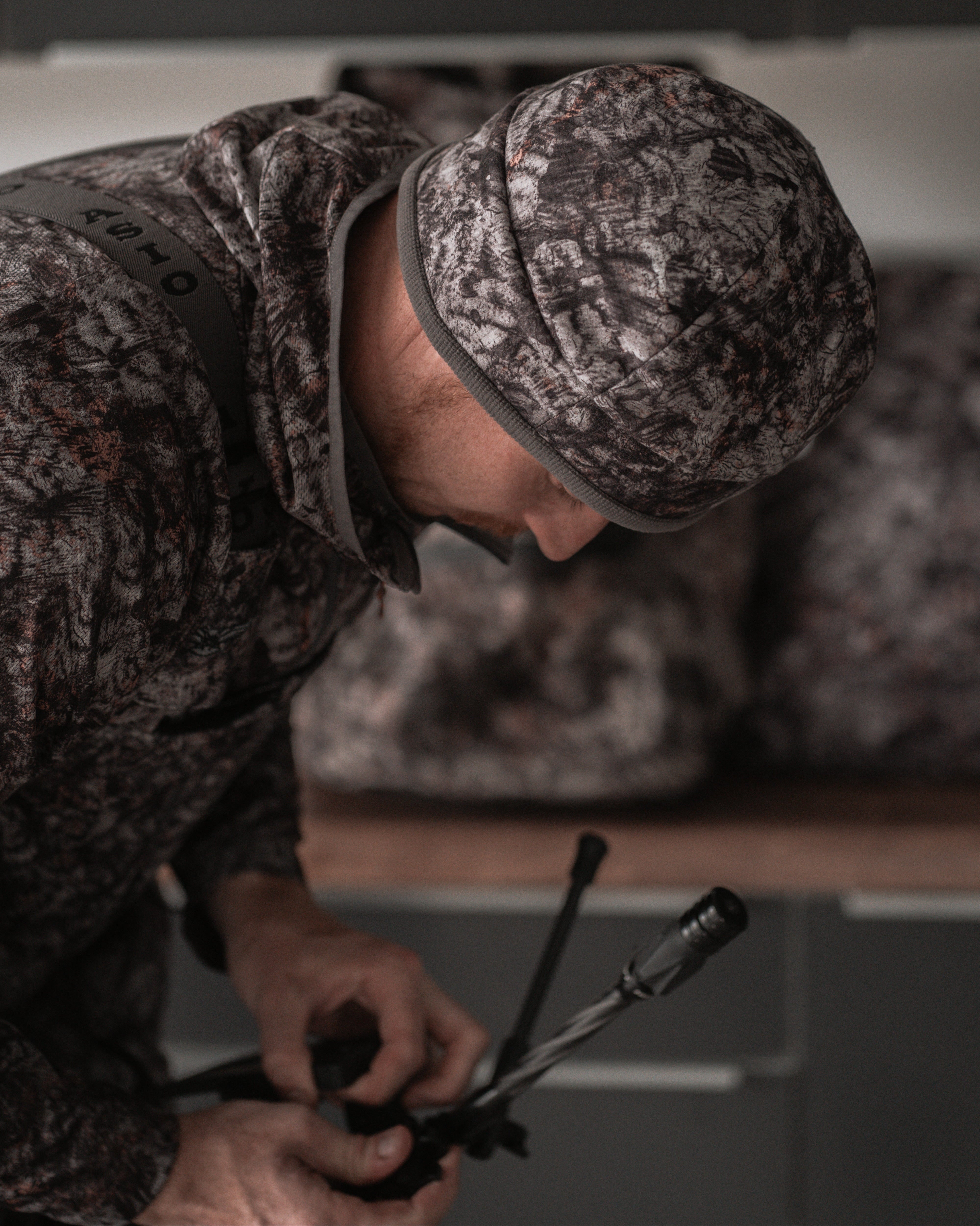 ASIO Gear RAPTOR camo sherpa-lined beanie worn during bowhunting gear prep for cold-weather hunts