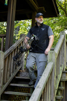 ASIO Gear man wearing black hunting vest holding bow
